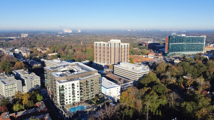 Obraz premium Aerial view complex of apartment buildings, hotel and cooperate towers with swimming pool in Brookwood Hills neighborhood area surrounded by colorful fall foliage autumn leaves
