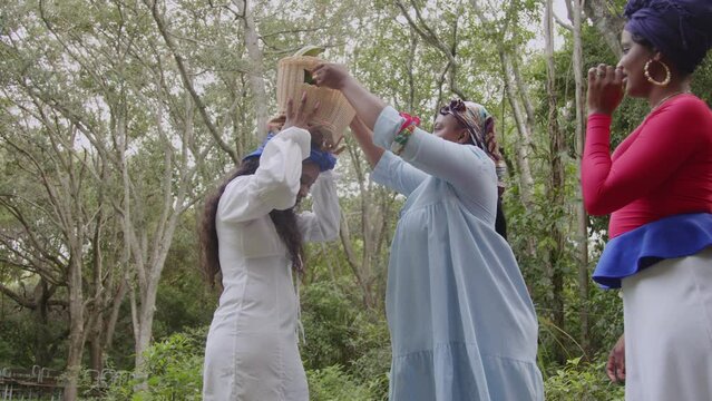 Woman helping friend carry fruit basket