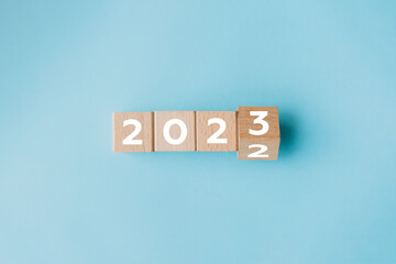 Flipping of 2022 to 2023 on wooden block cube for preparation new year change and start new business target strategy concept.