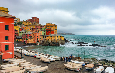 Scenic panoramic view of the ancient fishing village of Boccadasse with pastel-colored houses with green shutters, Cape Santa Chiara, a suburb of Genoa
