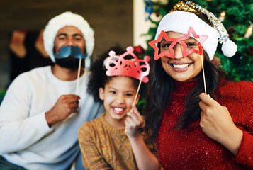Christmas, props and portrait of girl with family celebration with happy of mom, father and kid love together at home. Xmas vacation party, holiday bonding and mother with child smile in living room © N F/peopleimages.com