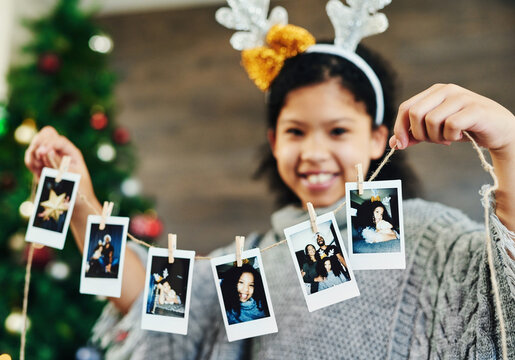 Girl portrait, polaroid and christmas celebration, happy smile and memories, photograph and decoration in home. Child, picture and string for xmas, celebrate and festive holiday, happiness and kid