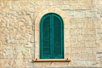 Fototapeta na wymiar Closed green shutter window in an old mansion. Background, wallpaper, texture