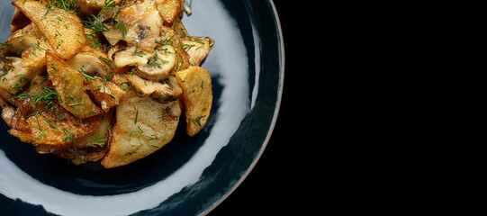 Fried potatoes with mushrooms on a dark background