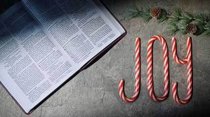 Bible and Joy Written With Candy Canes On Stone Table