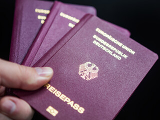 Three German passport in male hand on check in. Concept Idea