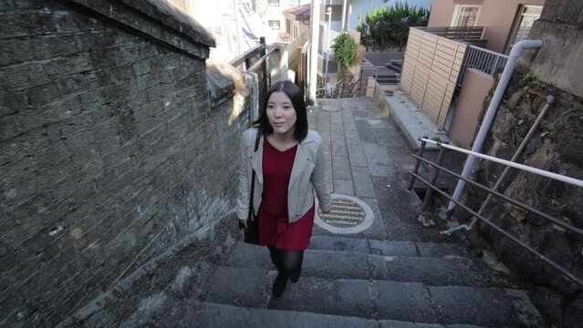 Young asian young girl walking up the historical stone stairs in Nagasaki Japan. Slow-mo.