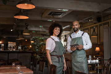 Portrait of restaurant owners holding a digital tablet
