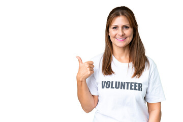 Middle age volunteer woman over isolated background pointing to the side to present a product