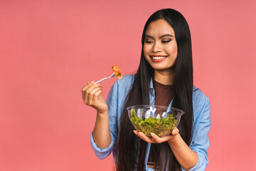 Clean eating diet concept. Asian woman holding vegeterian salad or bowl in take away container. Close up, copy space, isolated over pink background.