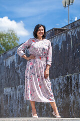 Obraz premium Portrait of a young beautiful woman posing against the backdrop of a city fountain