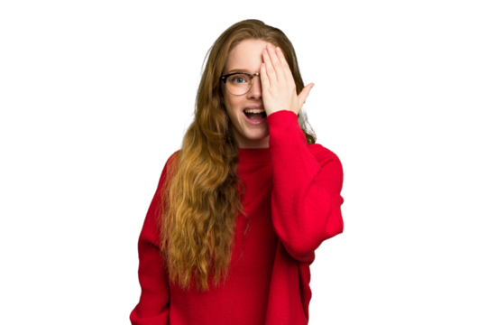 Young caucasian redhead woman isolated having fun covering half of face with palm.