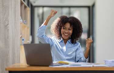 Excited happy Asian African woman looking at the laptop screen, celebrating an online win, overjoyed young African girl screaming with joy, isolated over a office background