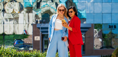 Two women posing against the backdrop of the business center