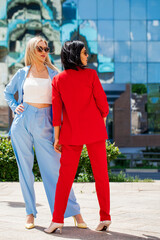 Fototapeta premium Two women posing against the backdrop of the business center