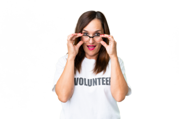 Middle age volunteer woman over isolated chroma key background with glasses and surprised
