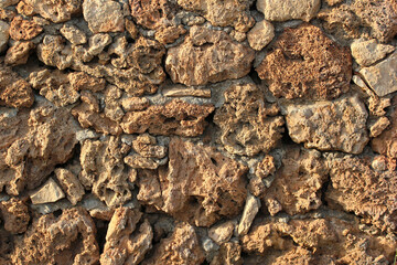 Rough stone wall background, rock texture closeup