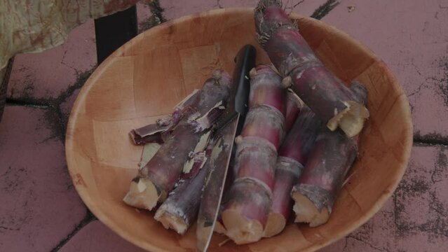 Sugar cane being cut into bowl