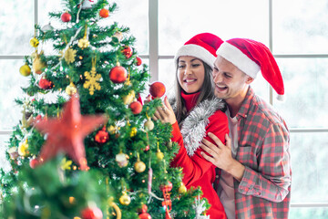 A young couple is celebrating their Christmas together happily at home.