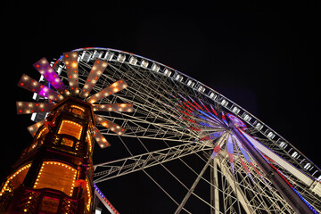 Ferris wheel and merry-go-round illuminated at night