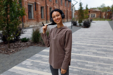 Portrait of a happy sports woman in headphones outdoors