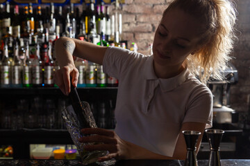 Woman bartender making an alcohol cocktail