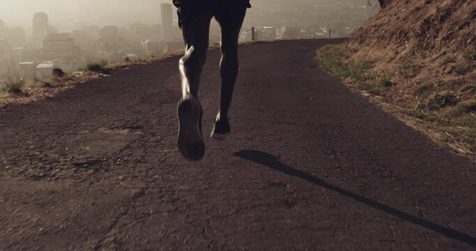 Running, mountain and feet of sports man for outdoor fitness, exercise and speed challenge in morning with sneakers. Asphalt road, runner or athlete black man with fast, power and muscle in his legs
