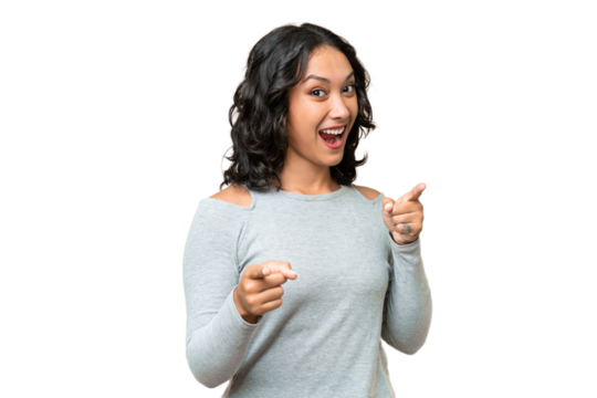 Young Argentinian woman over isolated background surprised and pointing front