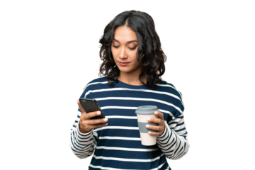 Young Argentinian woman over isolated background holding coffee to take away and a mobile