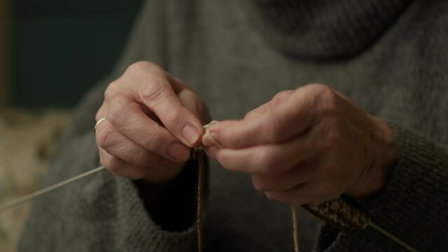 Senior Hands Knitting. Elderly female hands knitting close up.