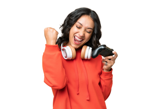 Young Argentinian woman playing with a video game controller over isolated background celebrating a victory