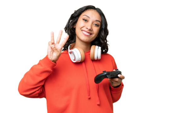 Young Argentinian woman playing with a video game controller over isolated background happy and counting three with fingers