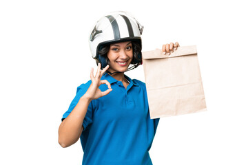 Young Argentinian woman taking a bag of takeaway food over isolated background showing ok sign with fingers