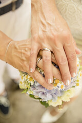 Obraz na płótnie Canvas Brautpaar mit sommerlichen Brautstrauss und schönen Händen