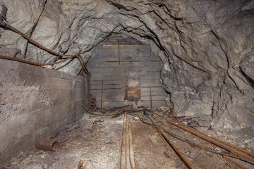 Old gold mine underground tunnel with hole door in wall stopping