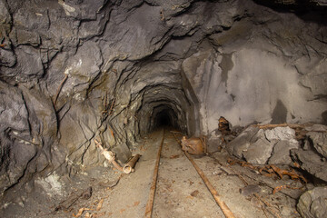 Obraz na płótnie Canvas Underground abandoned gold iron ore mine shaft tunnel gallery passage with rails