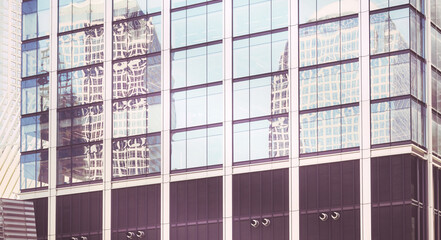 Buildings reflected in windows of a modern skyscraper, abstract urban background, color toning applied, New York City, USA.