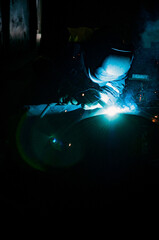 welder making weld joint with electric arc welding device