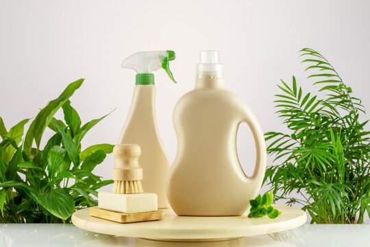 Natural cleaners, cleaning products, natural detergent bottles with soap and brush on wooden podium on gradient background with home plante. Mockup for natural detergents and cleaning products