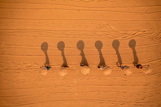 Aerial view of farmers working in a field drying rice on a rice field in Dhamrai, Dhaka, Bangladesh.