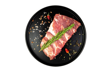 Seasoned pork ribs on a plate with spices, isolated on white, top view
