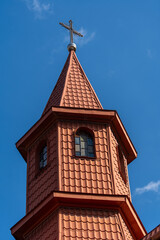Fototapeta na wymiar Metal cross with roof tiles in the blue sky background. Ukraine