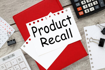 The text Product Recall . white keyboard red diary torn pages on the table