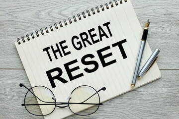the great reset,pen and glasses and text on a notebook page