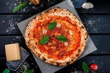 Fresh pizza with tomato sauce, garlic, spinach on thick dough.