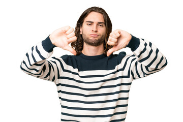 Young handsome man over isolated background showing thumb down with two hands