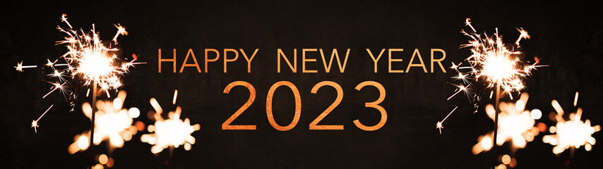 Happy new Year 2023 celebration background banner panorama long holiday greeting card - Many sparklers in the dark black night.