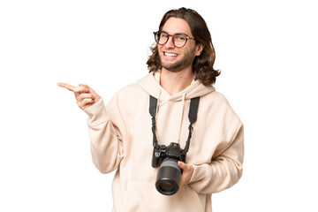 Young photographer man over isolated background pointing finger to the side - obrazy, fototapety, plakaty