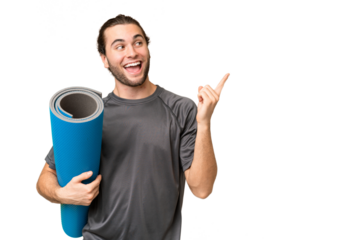 Young sport man going to yoga classes while holding a mat over isolated background intending to realizes the solution while lifting a finger up