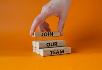 Join our team symbol. Wooden blocks with words Join our team. Beautiful orange background. Businessman hand. Business and Join our team concept. Copy space.